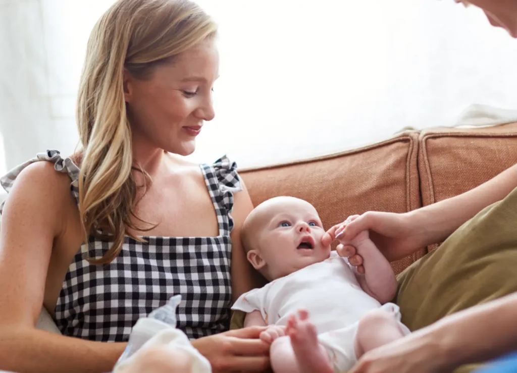 LGBT mothers holding and cuddling their newborn on a couch