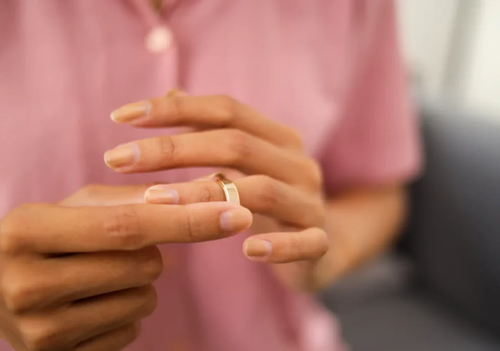 Close up of a woman's hands as she removes her wedding ring
